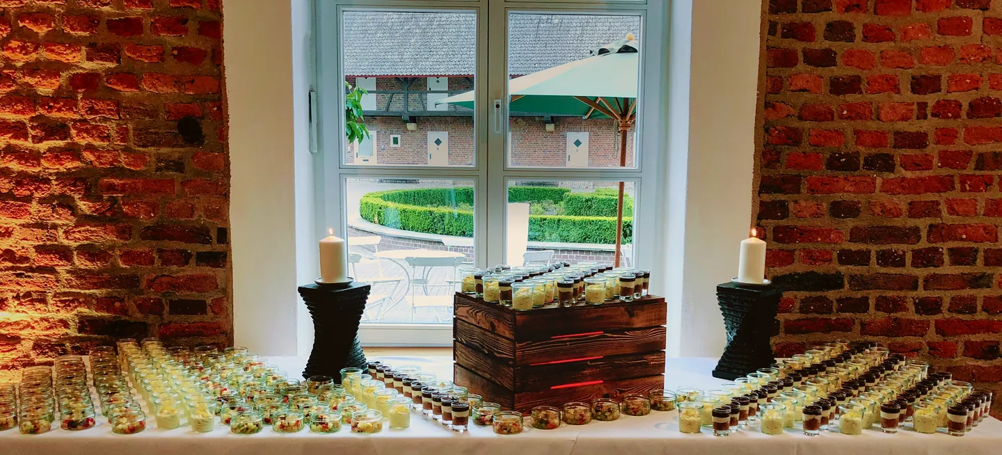 Dessertbuffet vor einer Backsteinwand und einem großen Fenster